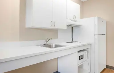a white kitchen with a sink and a microwave at Extended Stay America Suites - White Plains - Elmsford in Elmsford