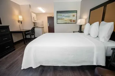 a hotel room with a large white bed and a desk at Extended Stay America Suites - Hartford - Farmington in Farmington