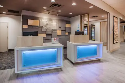 an office lobby with two counters with blue screens at Holiday Inn Express & Suites Woodside LaGuardia Airport in Queens