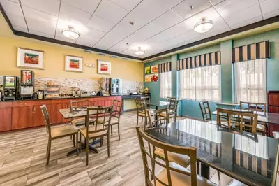 a restaurant with tables and chairs and a counter at Quality Inn Poughkeepsie in Poughkeepsie