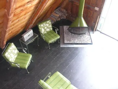 a room with two green chairs and a fireplace at Cabin Deck House - Formidable Cabin in Laurel Island in East Hampton