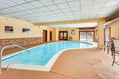 a pool in a hotel room with chairs and a table at Primely Located Dover Escape Less Than 1 Mi to Mt Snow! in Dover