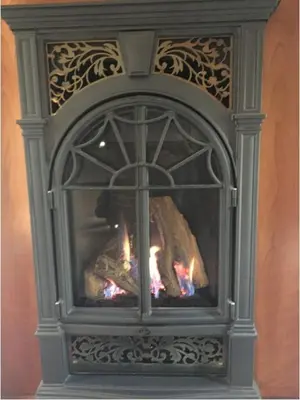a large fireplace with a fire in it at Raindrops On Roses Bed & Breakfast in Herkimer