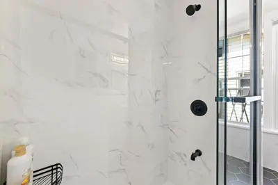 a white bathroom with a shower with a glass door at Cozy Gem in the Heart of East Rock with FREE Parking near Yale and DT in New Haven