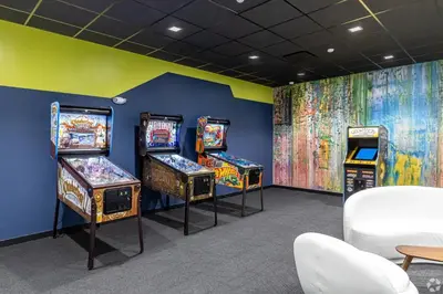 a room with three pinball machines and a mural at Fully Furnished Studio Wifi GYM Free Parking in Hartford