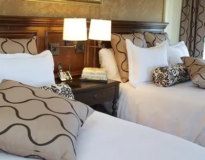 a hotel room with two beds and a table with a phone at Guest House at Norwalk Inn in Norwalk