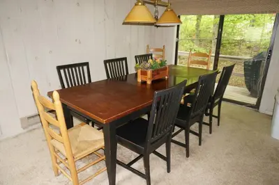 a dining room table with black chairs and a wooden table at 4BD 2BA - Mount Snow VT - Ski-Back Trail - Shuttle in Dover