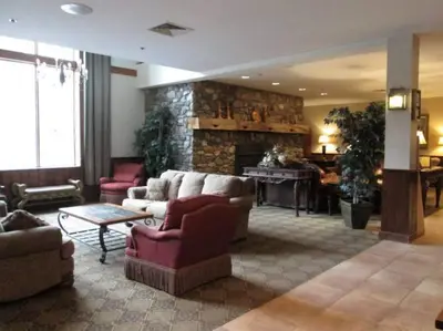 a living room with couches and a stone fireplace at Unique Yeti-Theme Ski On Off Suite Jiminy-Sleeps 4 in Hancock