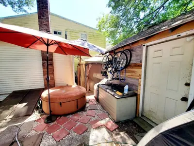 a patio with an umbrella next to a garage at Black-white Rm By Yale U in New Haven