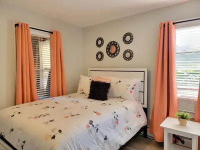 a bedroom with a bed and two windows with orange curtains at One room for rent shared bathroom and kitchen in Hartford