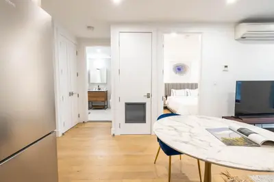 a kitchen and a living room with a table at 149BK-202 NEW Condo 1BR IN PRIME GREENPOINT BK in Brooklyn