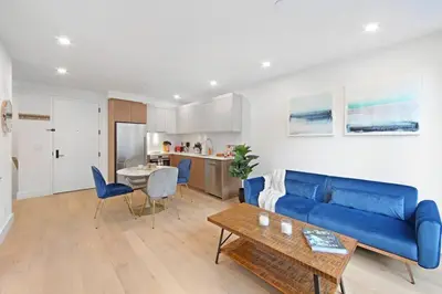 a living room with a blue couch and a table at 149BK-101 New construction 2BR Private garden W-D in Brooklyn