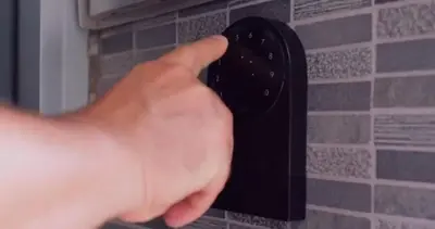 a person holding a black remote control on a wall at 75-2D NEW Prime UES W&D Balcony Elevator in New York