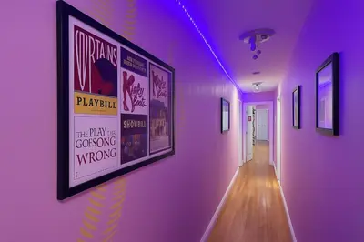 a hallway with a purple wall with posters on it at Blue style Room in Guesthouse in New York
