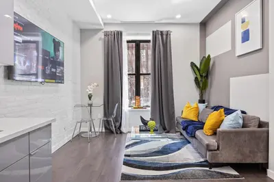 a living room with a couch and a kitchen at SWJ 1st - Near Most Attractions Walk to Train Times Sq near in New York