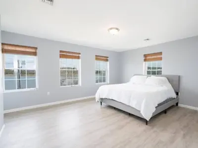 a white bedroom with a large bed and windows at Gorgeous Waterfront 2:1 - 2 houses in 1 building. in New Haven